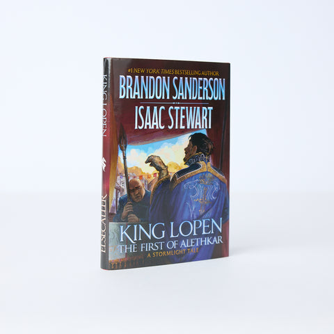 Hardcover book titled 'King Lopen The First of Alethkar' by Brandon Sanderson and Isaac Stewart on a neutral background
